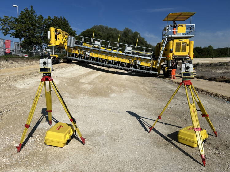 Special asphalt paver used for vehicle test tracks. Two total stations are used for the control of the machine.